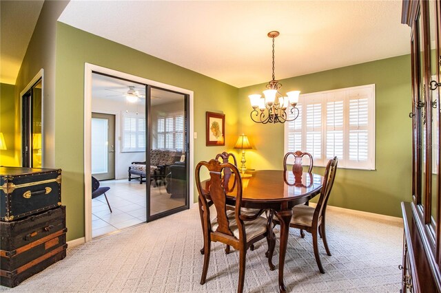 dining space featuring ceiling fan with notable chandelier and light carpet