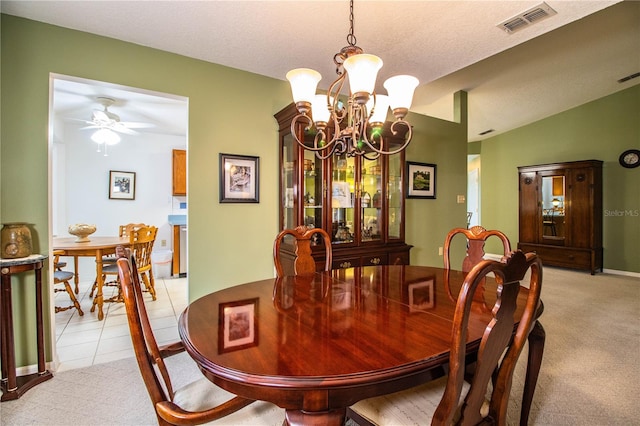 carpeted dining area featuring a textured ceiling, vaulted ceiling, and ceiling fan with notable chandelier