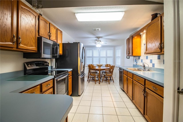 kitchen featuring stainless steel appliances, a textured ceiling, light tile patterned floors, ceiling fan, and sink