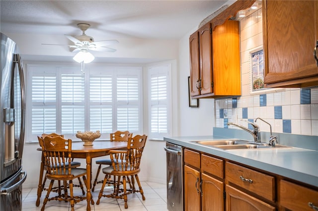 kitchen featuring appliances with stainless steel finishes, light tile patterned floors, sink, and tasteful backsplash