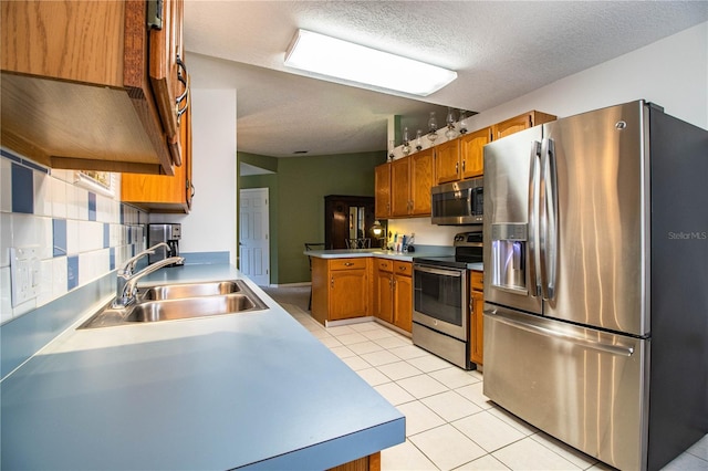 kitchen with tasteful backsplash, sink, stainless steel appliances, and light tile patterned flooring