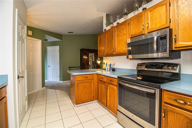 kitchen with light carpet, kitchen peninsula, a textured ceiling, and stainless steel appliances