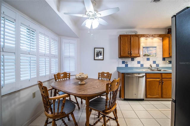 dining room with ceiling fan, light tile patterned floors, and sink