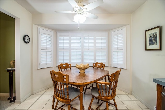 tiled dining space with ceiling fan and a wealth of natural light