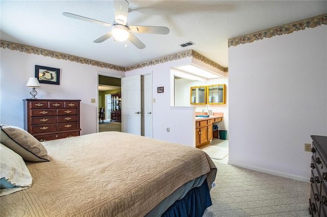 carpeted bedroom featuring ensuite bath and ceiling fan