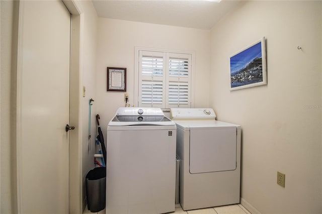 clothes washing area featuring light tile patterned floors and washing machine and clothes dryer