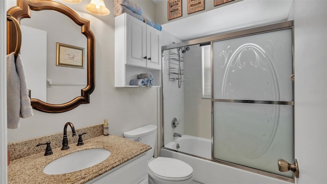 full bathroom with vanity, toilet, and bath / shower combo with glass door