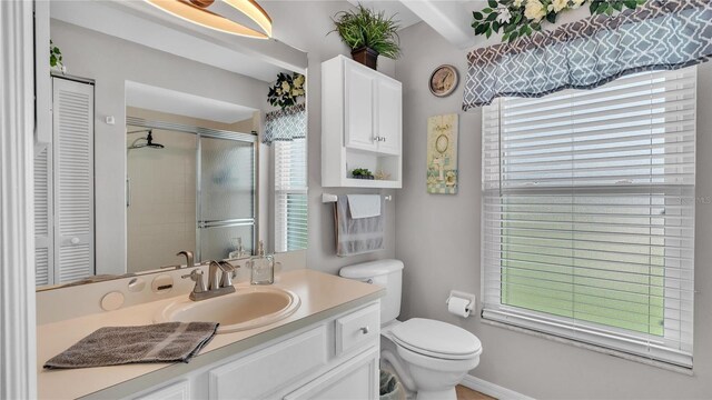 bathroom featuring toilet, an enclosed shower, and vanity