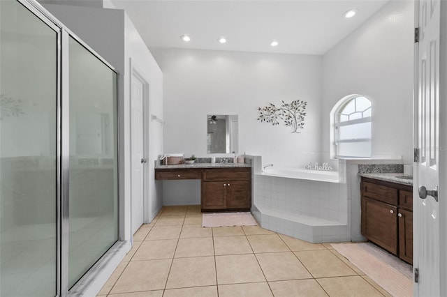 bathroom featuring tile patterned flooring, shower with separate bathtub, and vanity