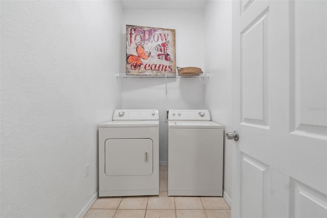 laundry area with light tile patterned floors and washing machine and dryer