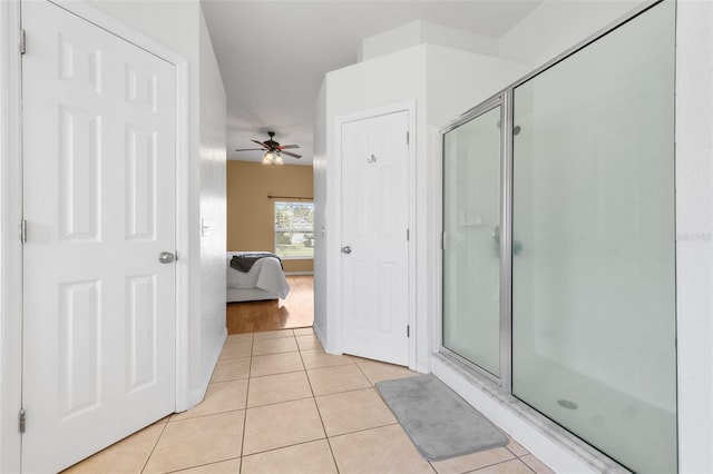 bathroom with ceiling fan, tile patterned flooring, and a shower with shower door