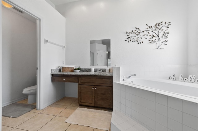 bathroom featuring toilet, tiled tub, tile patterned flooring, and vanity