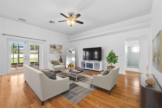 living room with light hardwood / wood-style flooring, french doors, and ceiling fan