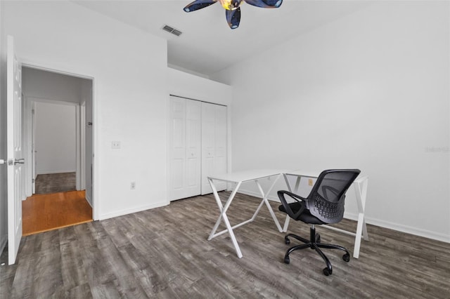 home office with ceiling fan and dark hardwood / wood-style flooring
