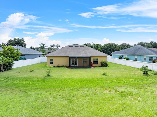 rear view of house featuring a lawn