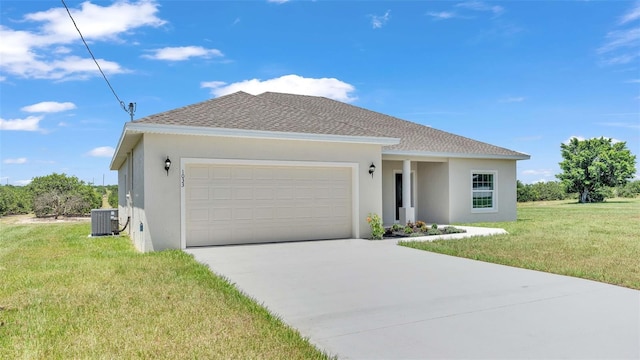 view of front of house with a garage, cooling unit, and a front lawn