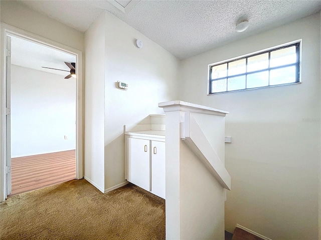 bathroom with ceiling fan and a textured ceiling