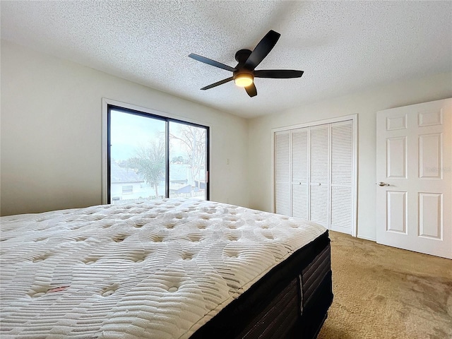 carpeted bedroom with access to outside, a textured ceiling, ceiling fan, and a closet