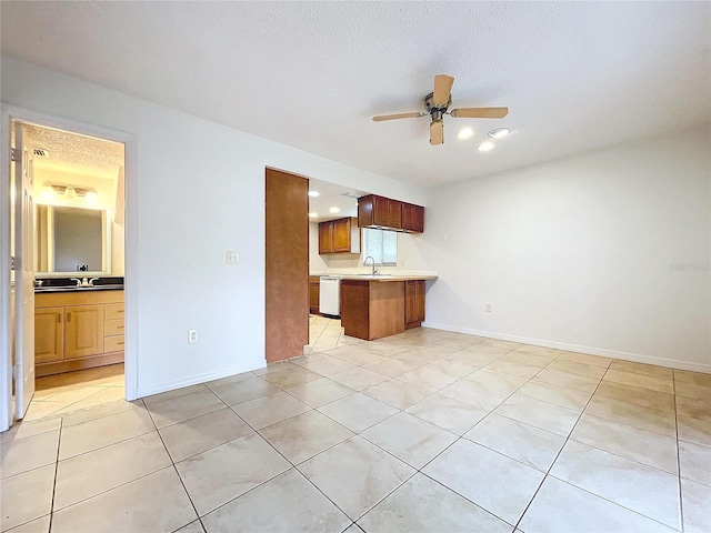 kitchen with dishwasher, sink, light tile patterned floors, ceiling fan, and kitchen peninsula