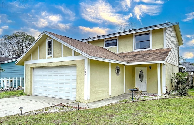 view of property with a garage and a front lawn