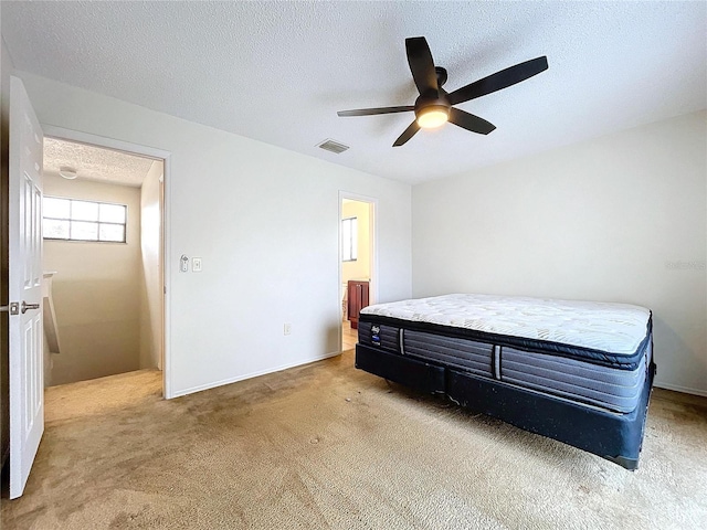 carpeted bedroom featuring a textured ceiling and ceiling fan