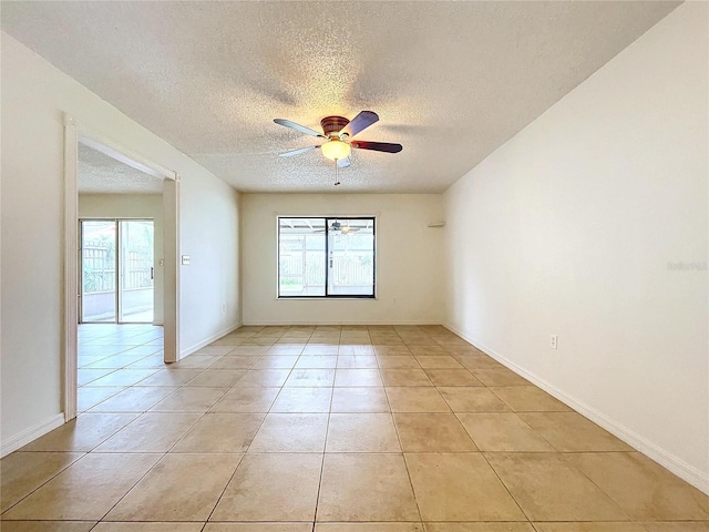 tiled spare room with a textured ceiling and ceiling fan