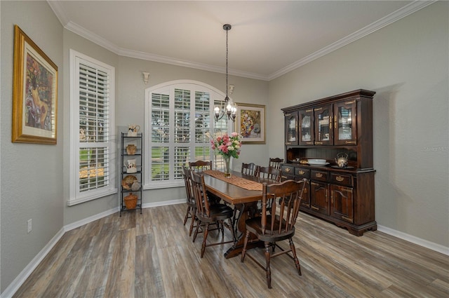 dining area with a notable chandelier, hardwood / wood-style flooring, and ornamental molding