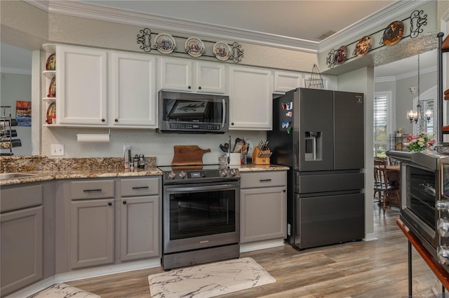 kitchen featuring gray cabinets, white cabinets, light hardwood / wood-style floors, stainless steel appliances, and crown molding