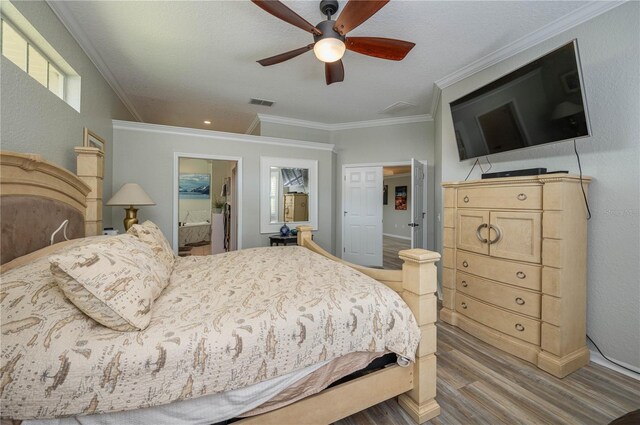 bedroom featuring ceiling fan, ensuite bath, crown molding, and hardwood / wood-style flooring