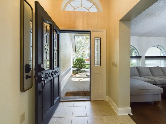 tiled entryway with a textured ceiling