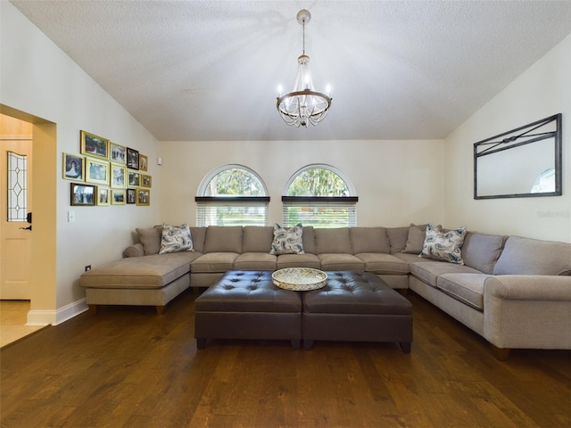 living room with a chandelier, dark wood-type flooring, a textured ceiling, and lofted ceiling