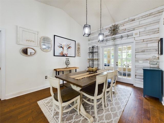 dining space with wooden walls, french doors, and dark hardwood / wood-style floors