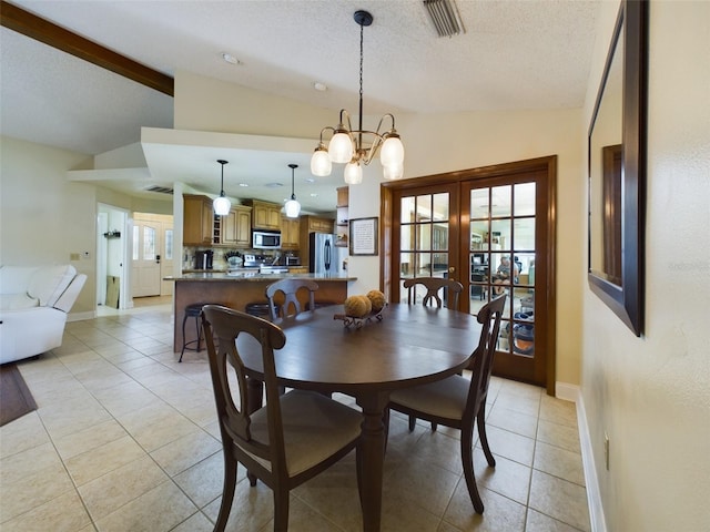 tiled dining room featuring a textured ceiling, plenty of natural light, and lofted ceiling