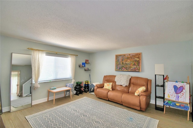 living room with a textured ceiling and light wood-type flooring