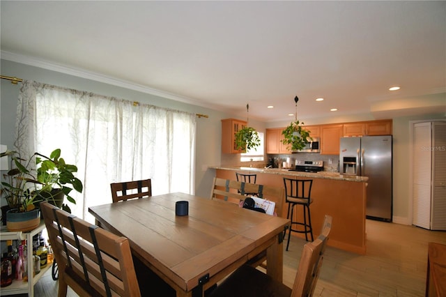 dining space featuring crown molding and light hardwood / wood-style flooring