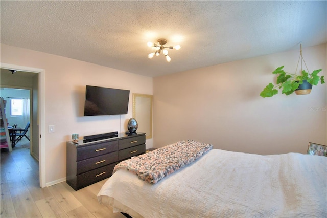 bedroom with light hardwood / wood-style flooring and a textured ceiling