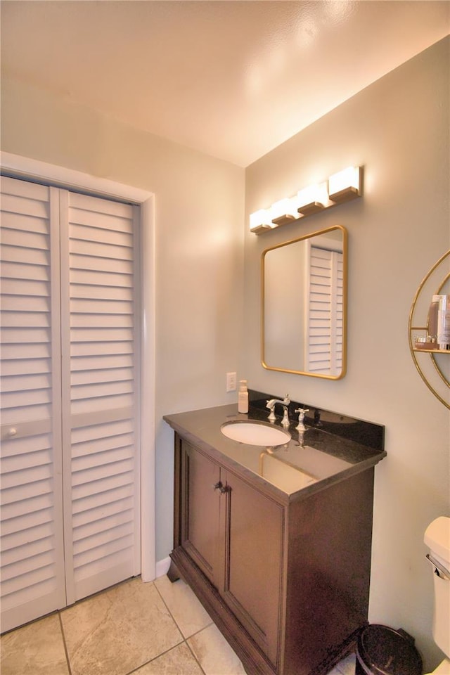 bathroom featuring vanity, tile patterned floors, and toilet