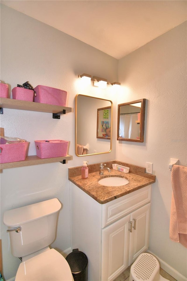 bathroom featuring vanity and toilet