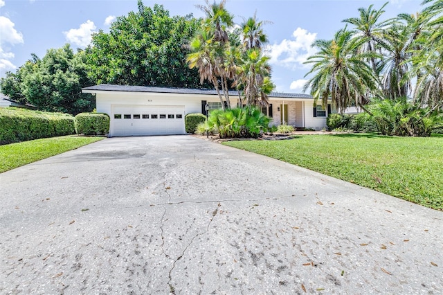 ranch-style home featuring a garage and a front lawn