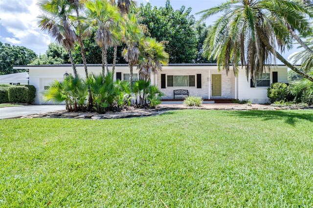 single story home featuring a garage and a front lawn