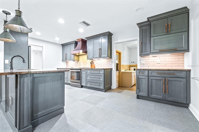 kitchen featuring pendant lighting, gray cabinets, decorative backsplash, custom exhaust hood, and stainless steel range with electric cooktop