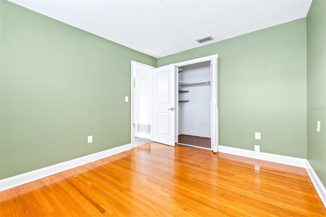 unfurnished bedroom featuring hardwood / wood-style flooring and a closet