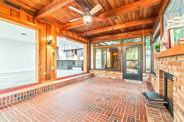 unfurnished sunroom featuring wood ceiling, ceiling fan, sink, and beamed ceiling