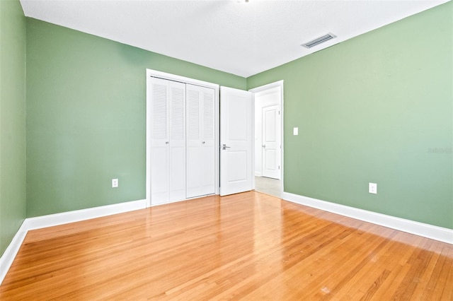 unfurnished bedroom featuring wood-type flooring and a closet