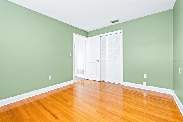 unfurnished bedroom featuring hardwood / wood-style flooring and a closet