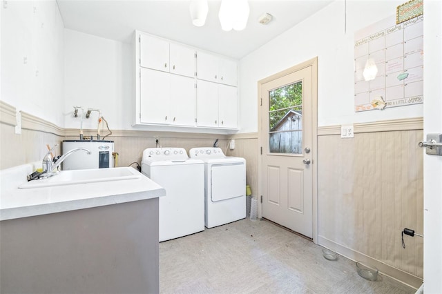 washroom featuring washer and dryer, sink, cabinets, and electric water heater