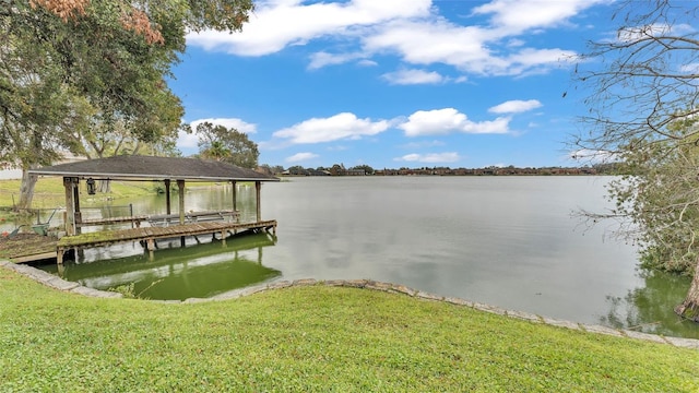 dock area featuring a lawn and a water view