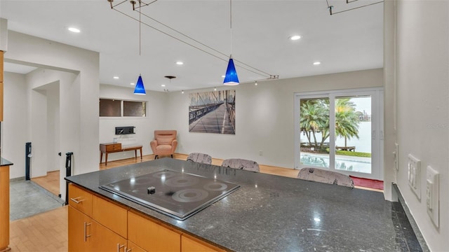 kitchen with dark stone countertops, black electric stovetop, and decorative light fixtures