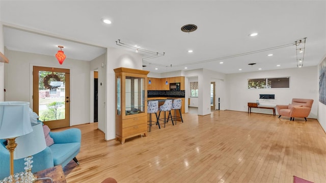 living room with track lighting and light hardwood / wood-style flooring