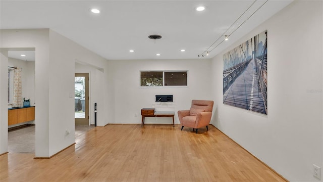 sitting room with rail lighting and light wood-type flooring